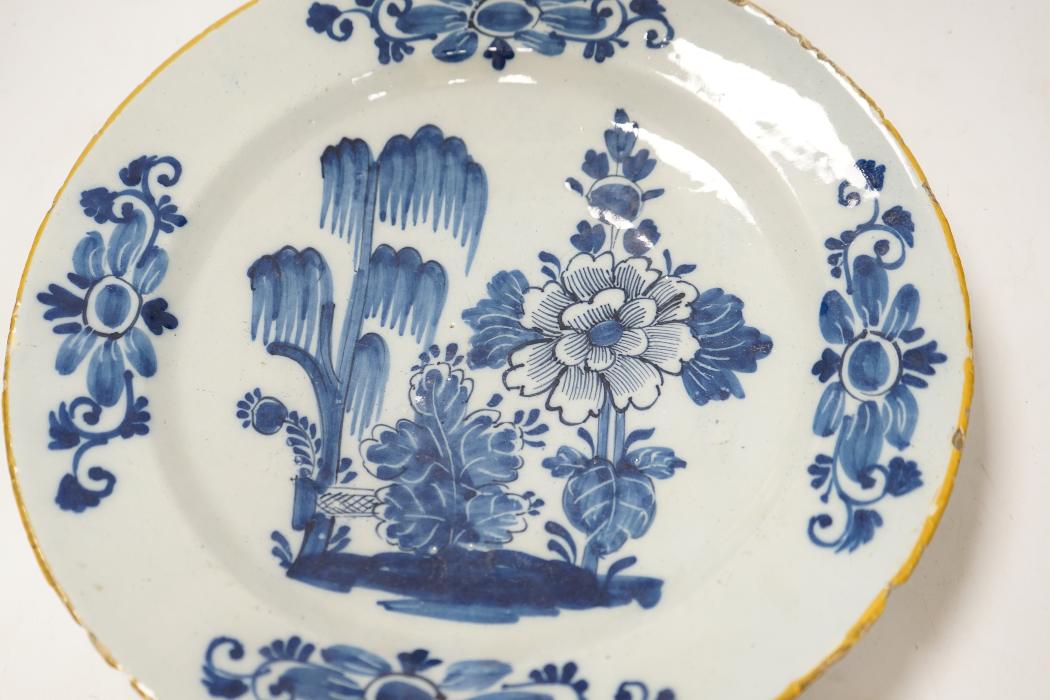 An 18th century delft blue and white dish, painted with a stylised peony and willow tree, 32cm diameter. Condition - fair, typical edge chipping all over